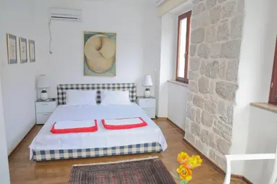 a bedroom with a bed with two red pillows on it at Luxury Waterfront Villa with Private Pool and Private Beach for 12 People in Kotor