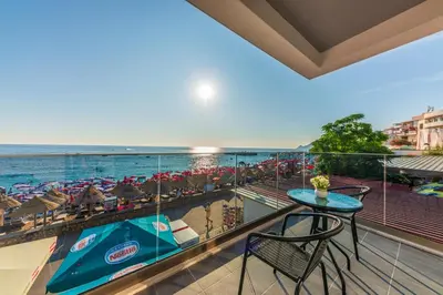 a balcony with a table and chairs and the ocean at Hotel Obala in Dobra Voda