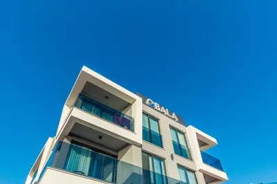a tall building with a blue sky in the background at Hotel Obala in Dobra Voda
