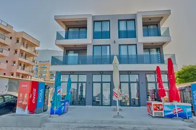 a building with closed umbrellas in front of it at Hotel Obala in Dobra Voda