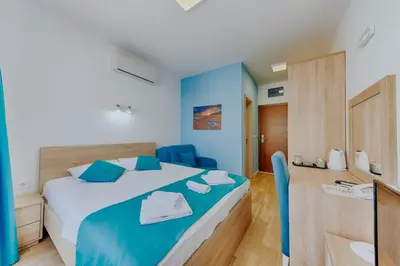 a bedroom with a bed and blue walls at Hotel Obala in Dobra Voda