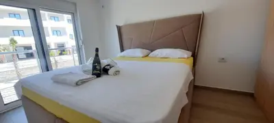 a bedroom with a bed with a headboard and a window at Studio Apartments Jupo in Ulcinj