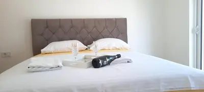 a bedroom with a bed with a suitcase on it at Studio Apartments Jupo in Ulcinj