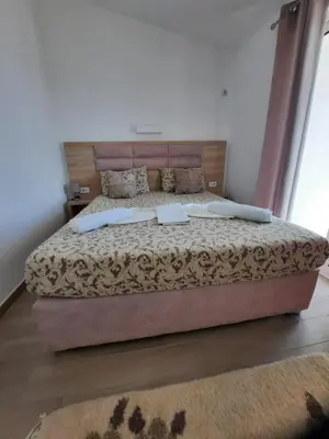 a bedroom with a large bed with a wooden headboard at Studio Apartments Jupo in Ulcinj