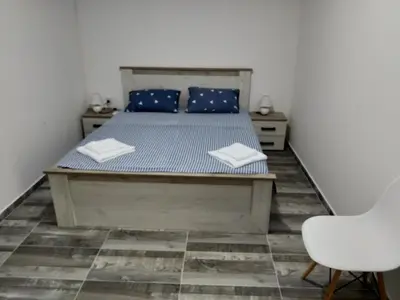 a bedroom with a bed with blue pillows and a chair at Take a Lake - Zabes, Virpazar in Virpazar