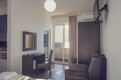 a living room with a desk and a chair in a room at Apartments Atlantis in Dobra Voda