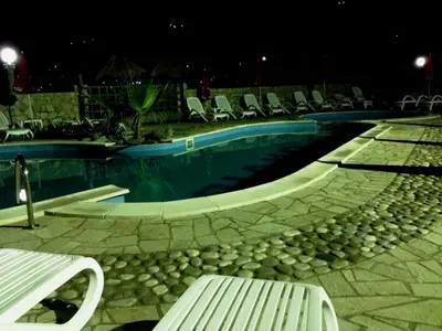 a swimming pool with chairs and a bench next to it at Apartments Atlantis in Dobra Voda