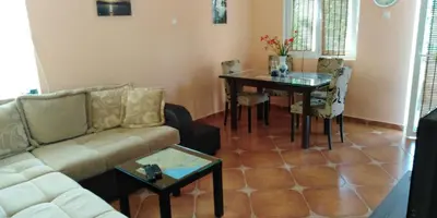 a living room with a couch and a table at Garden in Bar