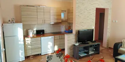 a kitchen with a refrigerator and a tv in it at Garden in Bar