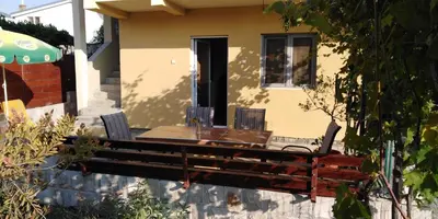 a wooden table and chairs in front of a house at Garden in Bar