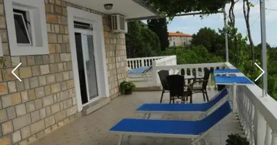 a porch with blue benches on a house at Apartments Dragišić in Sveti Stefan
