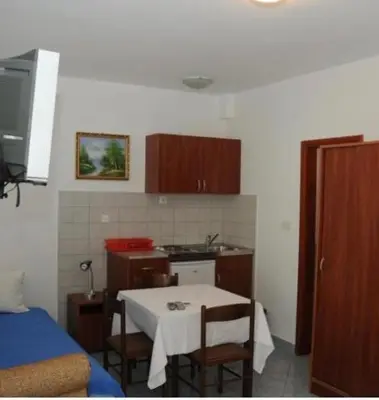 a small kitchen with a table and chairs in a room at Apartments Dragišić in Sveti Stefan