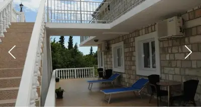 a balcony with chairs and a table on a building at Apartments Dragišić in Sveti Stefan