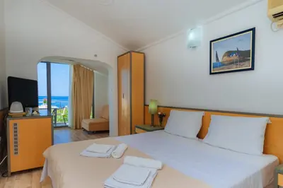 a bedroom with a large bed with a view of the ocean at Hotel Savojo in Petrovac na Moru