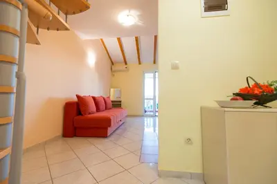 a living room with a red couch in a room at Vila Vukotić in Petrovac na Moru