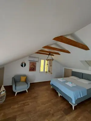 a bedroom with a bed and a couch and a chair at Art Apartments in Kotor