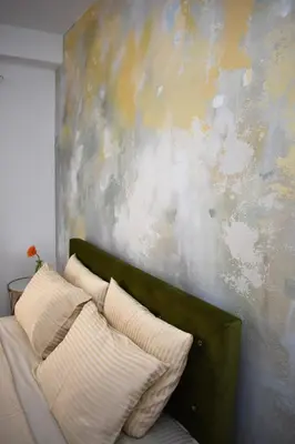 a couch with pillows in front of a wall at Art Apartments in Kotor