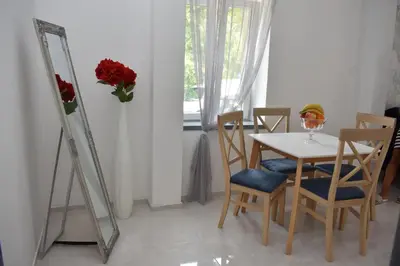 a dining room with a table and chairs and a mirror at Art Apartments in Kotor