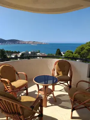 a patio with chairs and a table and a view of the ocean at Бар Шушань Апартаменты Главановича 25 in Bar
