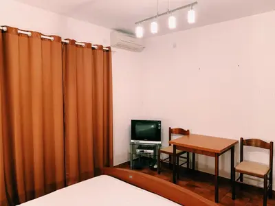 a room with a table and a television and a bed at Бар Шушань Апартаменты Главановича 25 in Bar