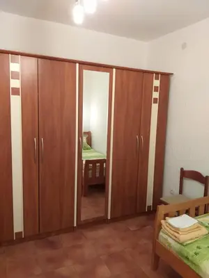 a room with wooden cabinets and a bedroom with a bed at Бар Шушань Апартаменты Главановича 25 in Bar
