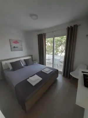 a bedroom with a large bed and a balcony at Apartman Danilo in Ulcinj