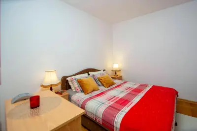 a bedroom with a bed and a table with a red candle at One bedroom apartment Ljilja in Sveti Stefan