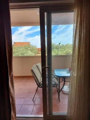 a balcony with a table and a glass door at One bedroom apartment Ljilja in Sveti Stefan