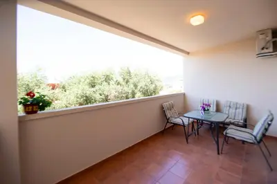 a balcony with a table and chairs and a window at One bedroom apartment Ljilja in Sveti Stefan