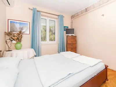 a bedroom with a bed and a window at Apartments StellaMar in Sveti Stefan