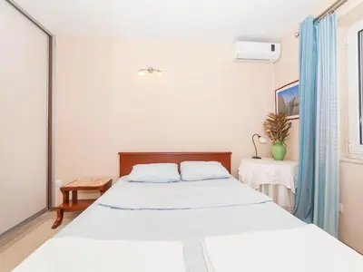 a bedroom with two beds and a window at Apartments StellaMar in Sveti Stefan