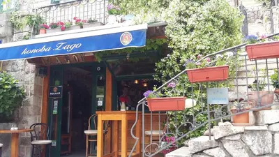a restaurant with a sign on the front of a building at Apartments StellaMar in Sveti Stefan