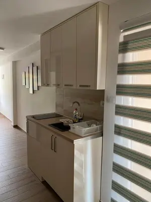 a kitchen with white cabinets and a sink at Apartments Boss in Budva