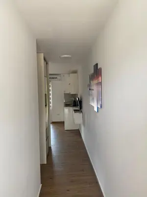 a hallway leading to a kitchen with white walls at Apartments Boss in Budva