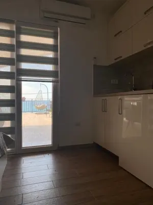 a kitchen with a sliding glass door to a playground at Apartments Boss in Budva