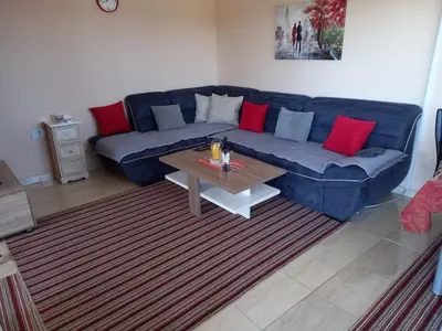a living room with a blue couch and a coffee table at Liza Apartment in Ulcinj