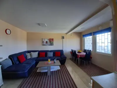 a living room with a blue couch and a table at Liza Apartment in Ulcinj