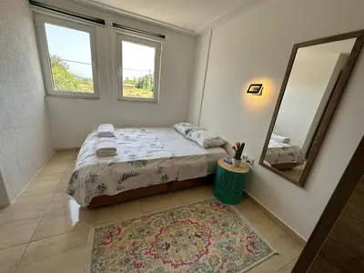 a bedroom with a bed and a mirror and a rug at Liza Apartment in Ulcinj