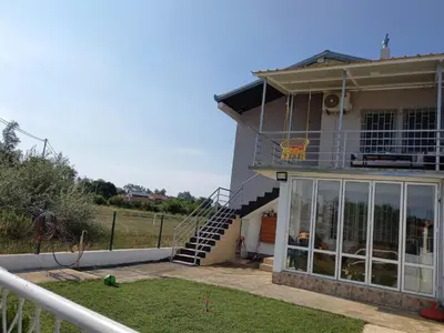 a house with a balcony and a stair case at Liza Apartment in Ulcinj