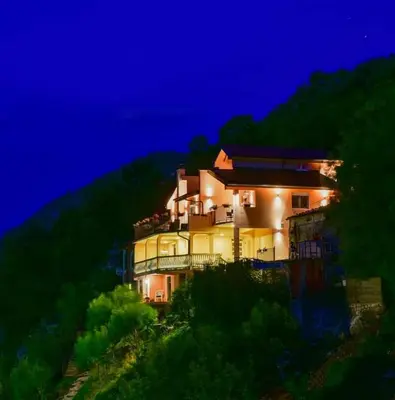 a large house on a hill at night at Lakeview Apartments Anđela in Virpazar