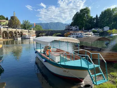 a boat is docked in the water near a bridge at Lakeview Apartments Anđela in Virpazar