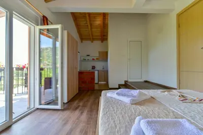 a bedroom with a bed and a large sliding glass door at Lakeview Apartments Anđela in Virpazar