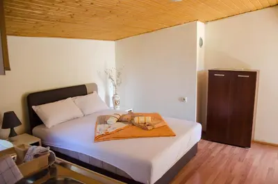 a bedroom with a bed with a tray with shoes on it at Studio-apartman Milena in Podgorica
