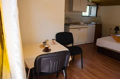 a small room with a table and chairs and a bed at Studio-apartman Milena in Podgorica