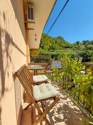 a patio with two chairs and a table on a balcony at Feel the village in Virpazar