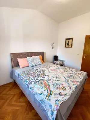 a bedroom with a large bed with a colorful quilt at Feel the village in Virpazar