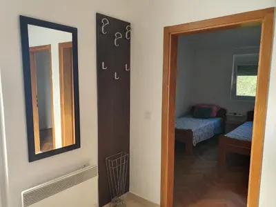 a room with a mirror and a bedroom with a bed at Feel the village in Virpazar