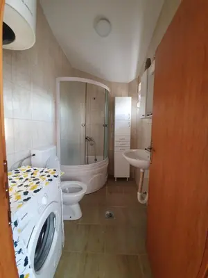 a bathroom with a washing machine and a toilet at Feel the village in Virpazar