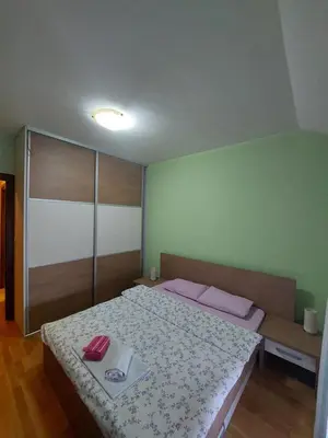 a bedroom with a large bed with pink pillows at Apartman Sara 2 in Podgorica