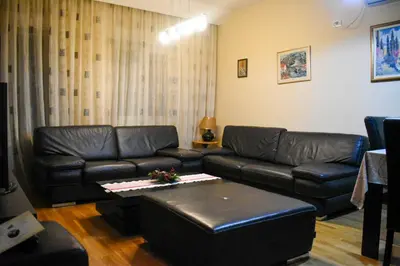 a living room with a leather couch and a table at Apartman Sara 2 in Podgorica